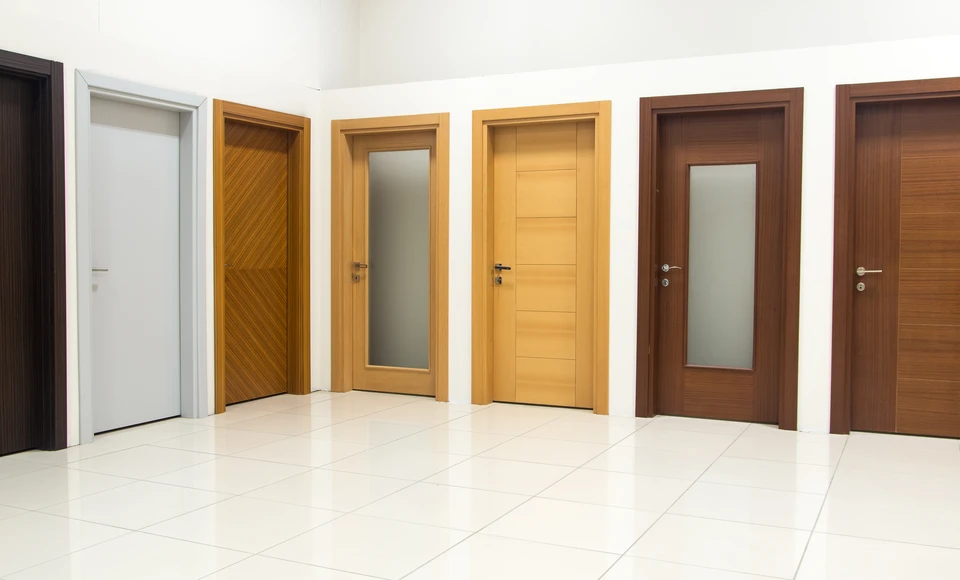 Showroom d'exposition de portes intérieures dans un espace commercial moderne avec sol en carrelage blanc brillant et murs blancs