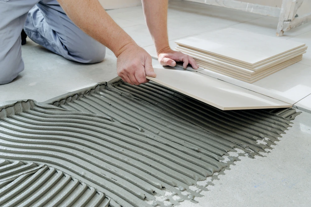 deux tiroirs professionnels installant des carreaux de grand format