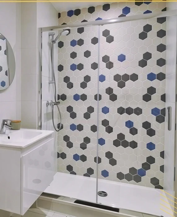 Salle de bain moderne avec douche à l'italienne équipée d'une paroi coulissante en verre transparent sur profilés aluminium chromés